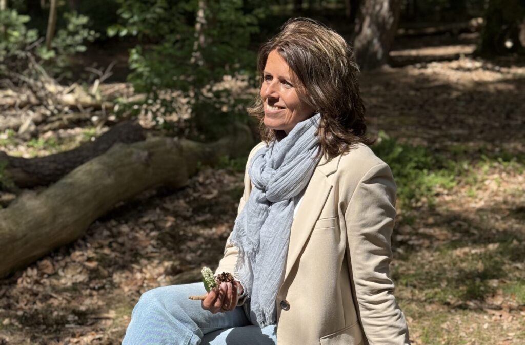 Kathy Kraak zit rustig op een boomstam in het bos - zenuwstelsel regulatie